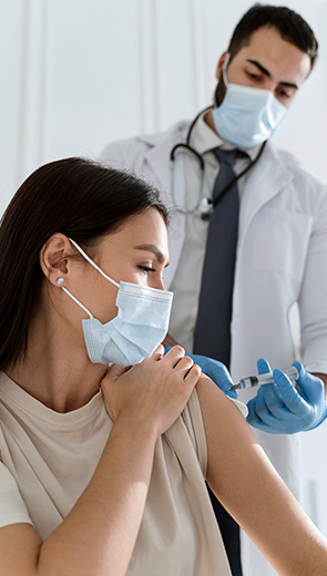 Doctor administering travel vaccine to patient at private clinic in Surrey