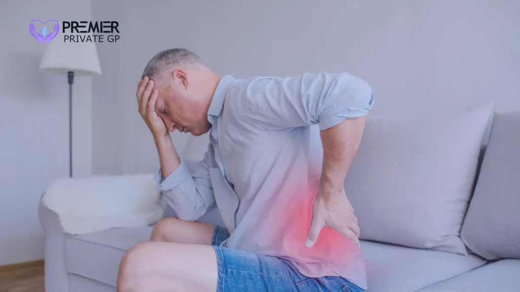 Man holding his lower back in pain after waking up with muscle strain.
